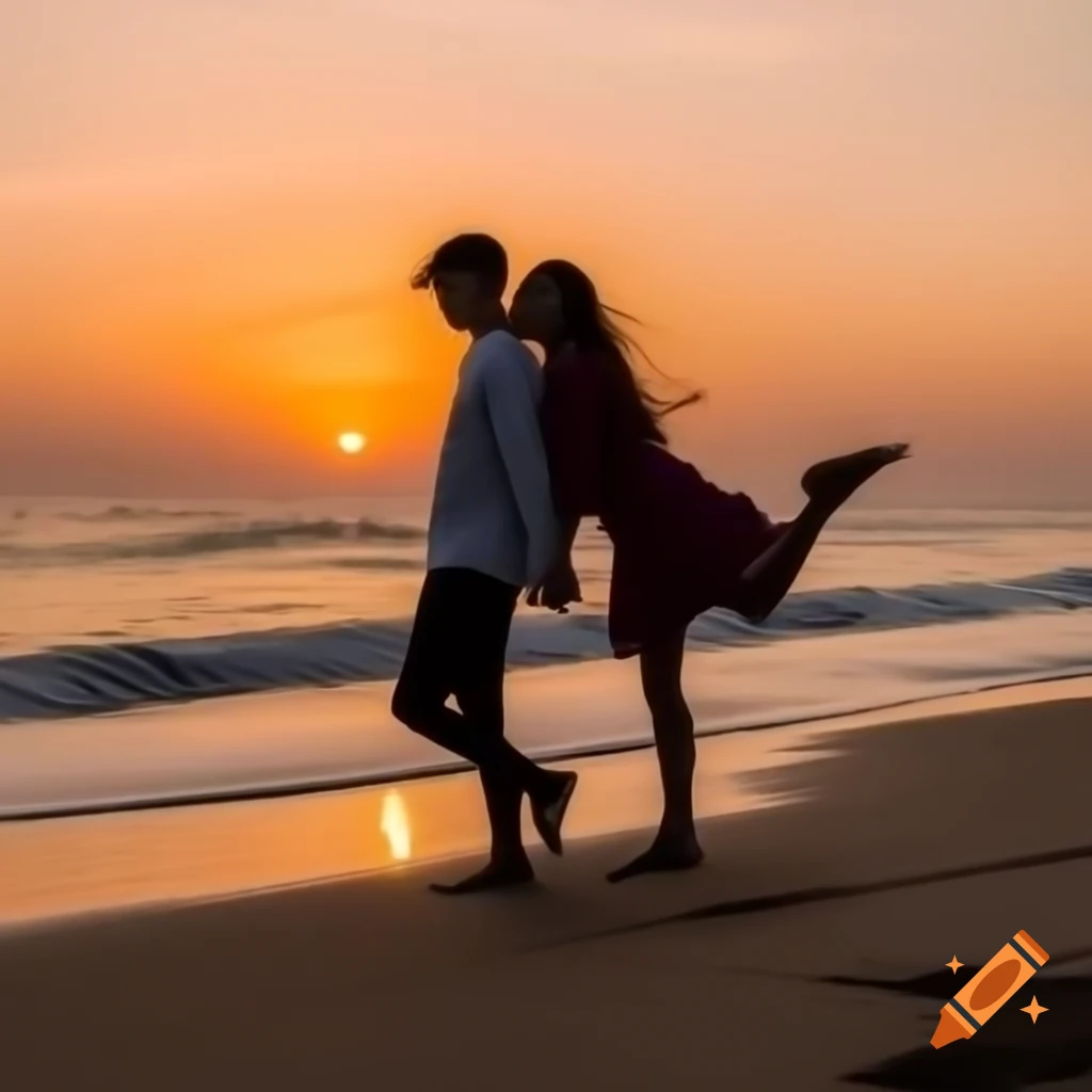Young couple laughing and walking along beach at sunset