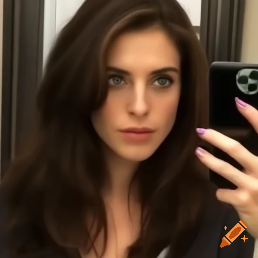 Candid selfie of a woman with dark brown hair and emerald eyes in the mirror